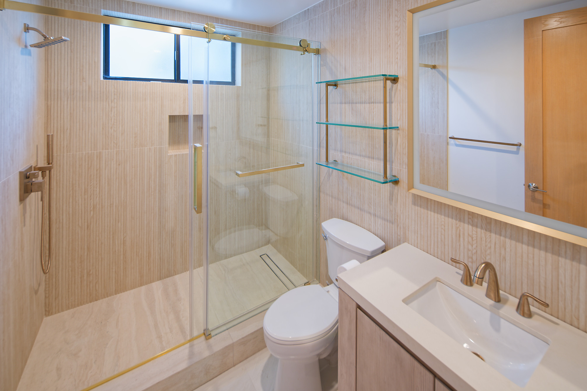Completed project — 22: Bathroom with glass shower enclosure, gold-toned fixtures, and vanity