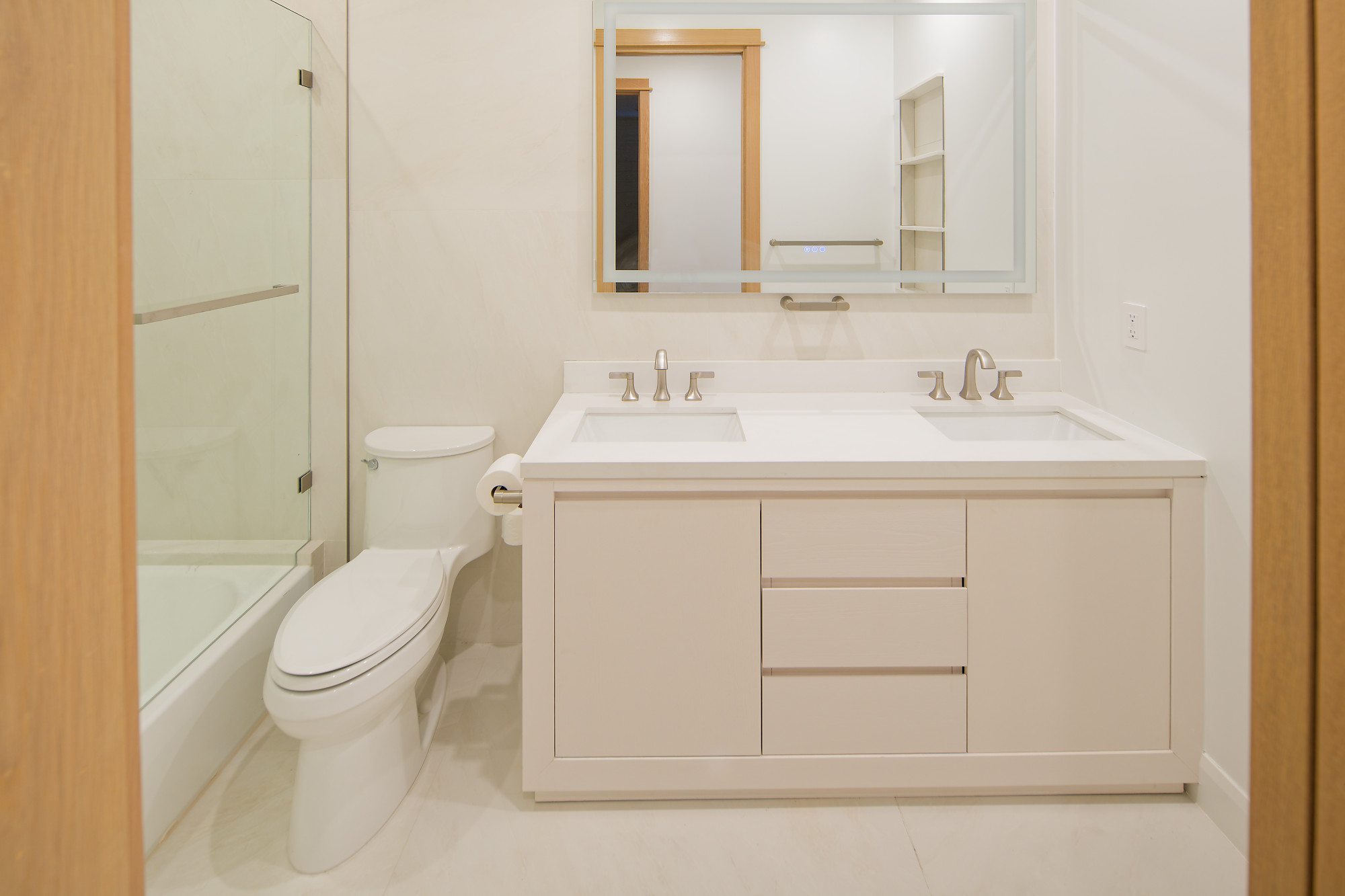 Completed project — 28: Bathroom with double-sink vanity, illuminated mirror, and glass shower